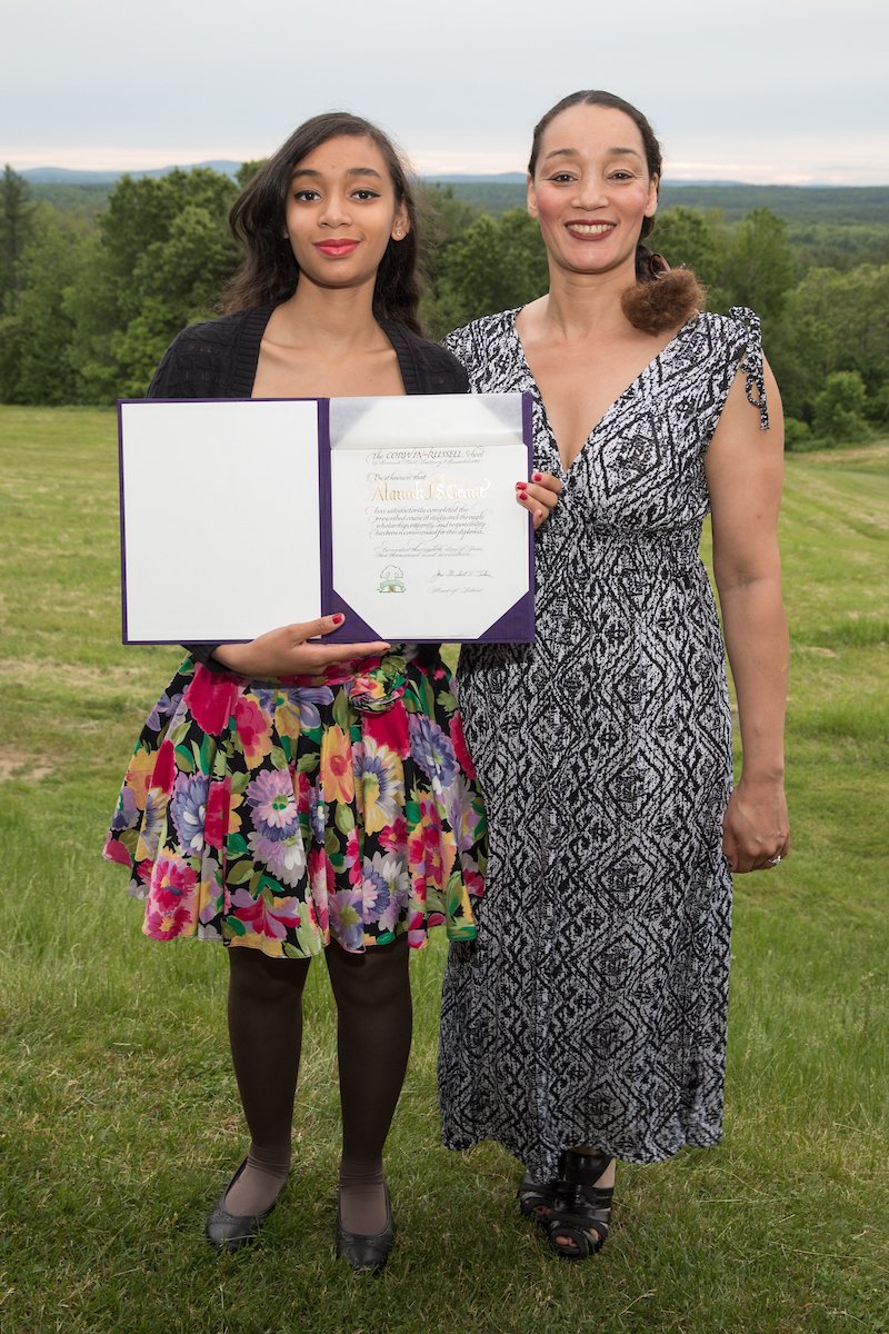 student with diploma standing with her parent